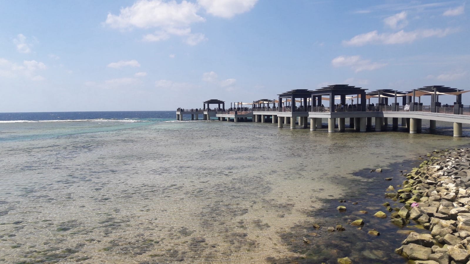 Shaded piers over the shallow Red Sea water on the Jeddah Corniche, Saudi Arabia