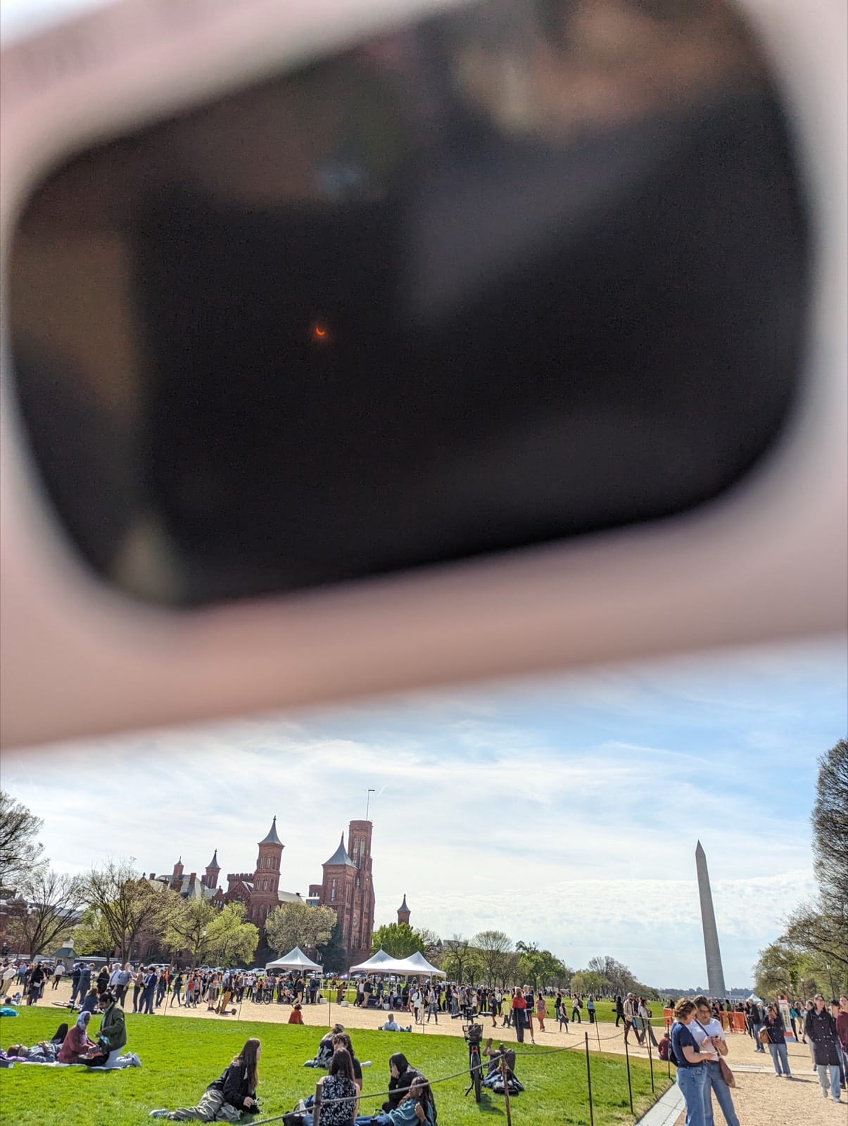 A person watching a partial solar eclipse through certified eclipse glasses