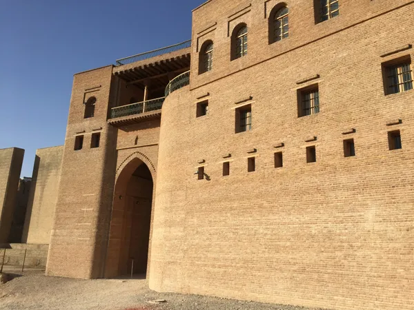 The brick walls and main gate of the Erbil Citadel in the Kurdistan Region of Iraq under a blue sky